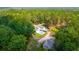 An aerial view of a rural home surrounded by lush, mature trees and featuring a pool and outbuilding at 2298 Cole Lake Rd, Dallas, GA 30157