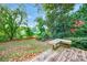 Spacious backyard with lush greenery and a wooden bench at 4599 Park Dr, Pine Lake, GA 30083