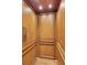 Interior view of a residential elevator showcasing wood paneling and recessed lighting at 4853 Stonehall Pl, Atlanta, GA 30339