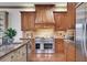 Well-appointed kitchen featuring a stainless steel stove, granite countertops, and custom wood cabinetry at 4853 Stonehall Pl, Atlanta, GA 30339