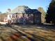 Expansive backyard view showcasing a large, two-story brick home with multiple windows at 354 Mansfield Way, Stockbridge, GA 30281