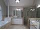 Luxurious bathroom featuring a soaking tub, glass shower, and double sink vanity at 354 Mansfield Way, Stockbridge, GA 30281
