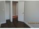 This bedroom features dark wood floors, and an open closet with a view into an adjacent room at 354 Mansfield Way, Stockbridge, GA 30281