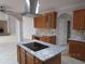Well-lit kitchen featuring granite countertops, stainless steel appliances, and a cooktop island at 354 Mansfield Way, Stockbridge, GA 30281