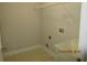 A well-lit laundry room with tile floors, a utility sink, and hookups for a washer and dryer at 354 Mansfield Way, Stockbridge, GA 30281