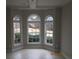Bright living room with three arched windows offering views of the landscaped front yard at 354 Mansfield Way, Stockbridge, GA 30281