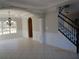 Spacious room with tile floors, wainscoting, staircase, chandelier, and an arched doorway at 354 Mansfield Way, Stockbridge, GA 30281