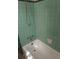 Clean bathroom with mint green tile and a white bathtub at 5094 Mable Lake Sw Dr, Mableton, GA 30126