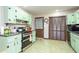 Kitchen features light green cabinets, stainless steel appliances, and vinyl flooring at 5094 Mable Lake Sw Dr, Mableton, GA 30126