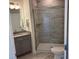 Bathroom features a walk-in shower with glass doors and stone-look tile at 5225 Maggie Mae Ln, Cumming, GA 30028