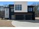 Modern two-story home featuring a black two-car garage, clean lines, and a geometric design at 1660 Union Grove Church Rd, Auburn, GA 30011