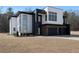 Contemporary home with striking black and white exterior, large windows, and a well-manicured front yard at 1660 Union Grove Church Rd, Auburn, GA 30011