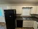 Kitchen with white cabinets, black appliances, and dark countertops at 194 Spring Leaf Dr, Dallas, GA 30157