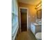 Bathroom featuring a single vanity sink, vinyl floor, and a doorway to the bedroom at 3715 Leisure Ln, College Park, GA 30349