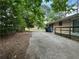 View of the driveway leading to the side of the house with mature trees providing shade at 3715 Leisure Ln, College Park, GA 30349