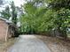 View of the brick house with an expansive driveway and natural landscaping at 3715 Leisure Ln, College Park, GA 30349