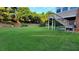 Expansive backyard with lush green grass, wooden staircase and mature trees providing privacy at 3450 Camellia Ln, Suwanee, GA 30024