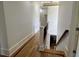 Hallway with hardwood floors and staircase creates an inviting transition between floors at 3450 Camellia Ln, Suwanee, GA 30024