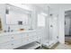 Bright bathroom featuring double vanity with white countertop, large mirror, and glass-enclosed shower at 1377 Oak Grove Dr, Decatur, GA 30033