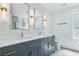 Modern bathroom featuring double sinks, brass fixtures, and a decorative wallpaper at 1377 Oak Grove Dr, Decatur, GA 30033