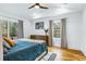 Main bedroom with tray ceiling, hardwood floors, and windows to a wooded view at 1377 Oak Grove Dr, Decatur, GA 30033