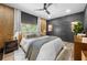 Bright bedroom featuring a king-size bed and wood accent wall at 648 Glendale Rd, Scottdale, GA 30079