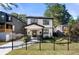 Two-story house with white siding, black accents, and a black metal fence at 648 Glendale Rd, Scottdale, GA 30079