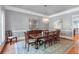 Formal dining room with hardwood floors, chandelier, and elegant dining table set for eight at 5040 Harrington Rd, Johns Creek, GA 30022