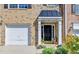 Welcoming front door entrance featuring classic columns, pumpkins, and a one-car garage with brick facade at 3676 Chattahoochee Summit Dr, Atlanta, GA 30339