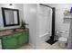 Well-lit bathroom with a green vanity, shower, and decorative shelving at 2700 Pine Tree Ne Rd # 2108, Atlanta, GA 30324