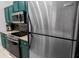 Close-up of kitchen featuring stainless steel appliances and trendy green cabinets at 2700 Pine Tree Ne Rd # 2108, Atlanta, GA 30324