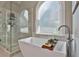 Bathroom with large soaking tub, glass shower, and arched window at 160 Isleworth Way, Fayetteville, GA 30215