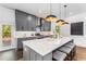 Modern kitchen with gray cabinets, stainless steel appliances, large island with seating, and herringbone backsplash at 971 Washington Sw Pl, Atlanta, GA 30314