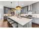 Well-appointed kitchen featuring a large island, gray cabinetry, modern lighting, and stainless steel appliances at 971 Washington Sw Pl, Atlanta, GA 30314