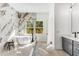 Luxurious main bathroom featuring a soaking tub, a marble accent wall, and natural light from the windows at 971 Washington Sw Pl, Atlanta, GA 30314