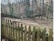 View of an overgrown backyard with a wooden fence and natural foliage at 26 Flint Ridge Se Dr, Mableton, GA 30126