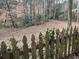 Overgrown backyard with an old wooden fence and natural foliage at 26 Flint Ridge Se Dr, Mableton, GA 30126