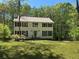 Traditional two-story home with green shutters, a manicured lawn, and mature trees around property at 26 Flint Ridge Se Dr, Mableton, GA 30126