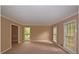 Bright living room with neutral carpet, two large windows, and open access to other rooms at 26 Flint Ridge Se Dr, Mableton, GA 30126