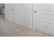 A long hallway with white doors and neutral-colored carpet at 179 Hampton Cir, Mcdonough, GA 30253