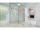 Modern glass enclosed shower with dual shower heads and a view of the fireplace in the main bedroom at 3707 Peachtree Ne Rd # 1, Atlanta, GA 30319