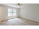 A simple, neutral bedroom space featuring carpet, window, and multiple closet doors at 798 Tommy Lee Cook Rd, Palmetto, GA 30268