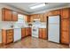 Traditional kitchen featuring wood cabinets, white appliances, and laminate flooring at 798 Tommy Lee Cook Rd, Palmetto, GA 30268