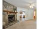 Cozy living room featuring a stone fireplace and open layout into the adjacent kitchen at 798 Tommy Lee Cook Rd, Palmetto, GA 30268