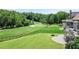 A serene backyard featuring a well-maintained lawn, spacious deck, patio, and fire pit, perfect for outdoor gatherings and relaxation at 8150 Albritton Downs, Cumming, GA 30041
