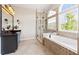 Luxurious bathroom with a soaking tub, glass shower, and large window for natural light at 8150 Albritton Downs, Cumming, GA 30041