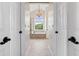 Elegant bathroom with a chandelier view down hallway leading to soaking tub at 8150 Albritton Downs, Cumming, GA 30041