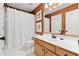 Well-lit bathroom with single sink vanity, framed mirror, and shower with white curtain at 8150 Albritton Downs, Cumming, GA 30041