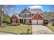 Beautiful two-story brick home with a well-manicured lawn, mature landscaping, and a welcoming front porch at 8150 Albritton Downs, Cumming, GA 30041