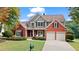 Attractive brick home with well-maintained lawn, two-car garage, and inviting front porch at 8150 Albritton Downs, Cumming, GA 30041